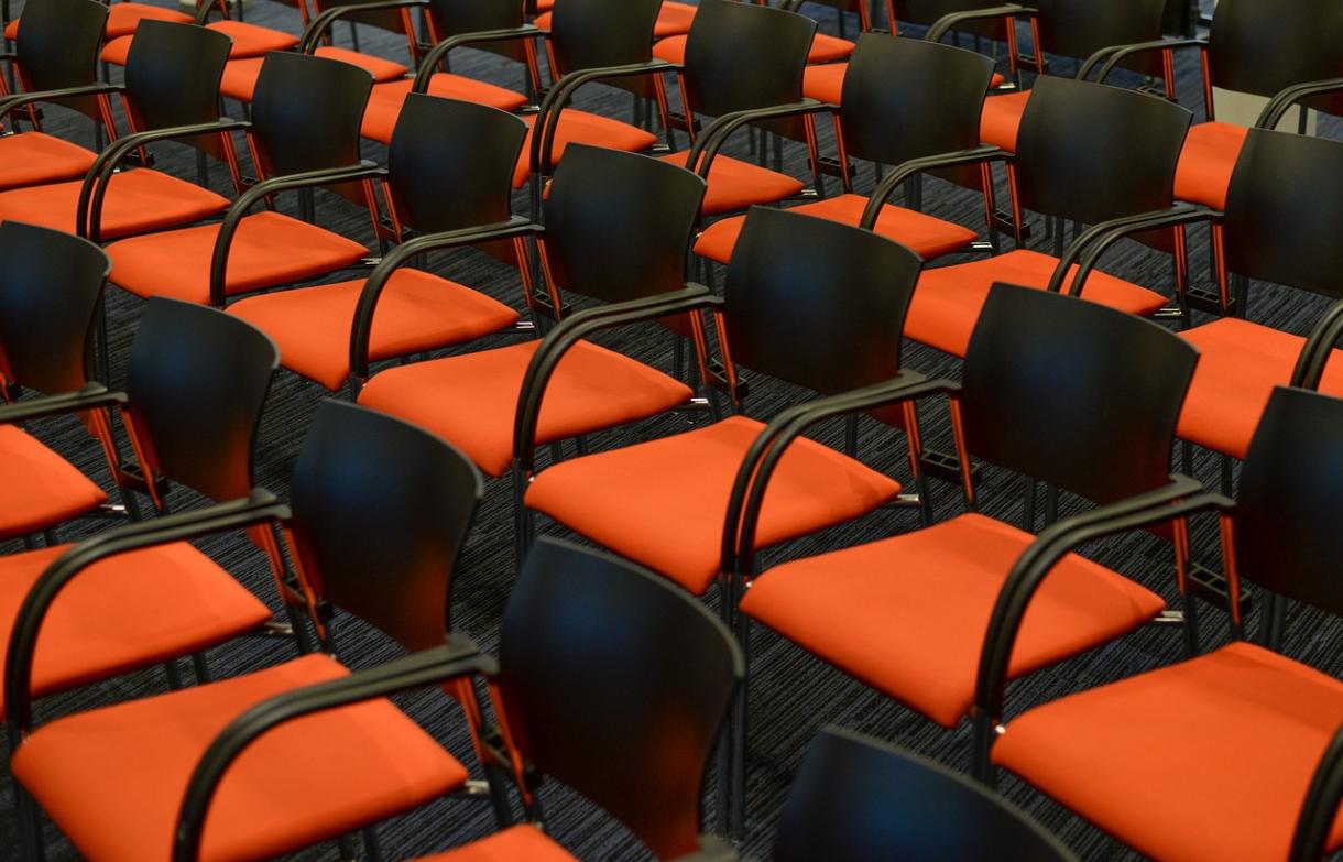Afbeelding oranje stoelen in auditorium
